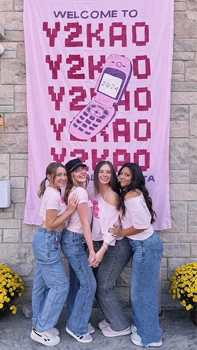 4 women standing in front of a Welcome to Y2KAO sign
